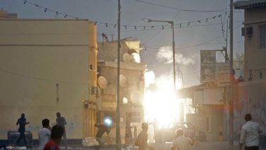 Different  goals ... protesters in Bahrain react to an explosion as riot police open fire at Pearl Square.