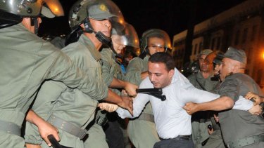 Policemen arrest a protester during a demonstration in Rabat, Morocco on the release of a Spanish pedophile, Daniel Fino Galvan who raped 11 local children was pardoned by the Moroccan King Mohammed VI.