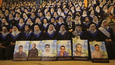 Palestinians graduating at Gaza City's University College of Applied Sciences on Wednesday sit behind pictures of classmates killed during Israel's Operation Protective Edge offensive in the territory.