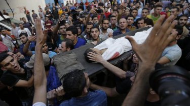 Palestinians chant slogans as mourners carry the body of Muhammed Abu Shagfa, 7, killed in an explosion, during the funeral in Shati refugee camp, in the northern Gaza Strip.