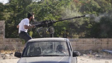 A Free Syrian Army fighter fires a machine gun on the front line in Aleppo.