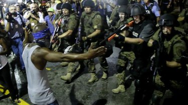 Police arrest a man as they disperse protesters in Ferguson, St Louis.