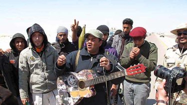 Benghazi coffee shop owner Masoud Bwisir sings a rebel song on the road 150 kilometres south-west of his home.