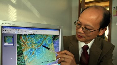 Dr Linlin Ge  with a Japanese satellite image of Sichuan after the earthquake.