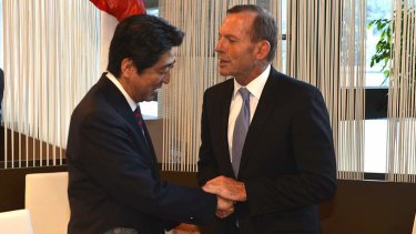 Pressing the flesh: Japanese Prime Minister Shinzo Abe meets Tony Abbott in Davos at the four-day World Economic Forum.
