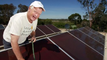 Don Chambers cleans the solar panels on the roof of his Rutherglen house.