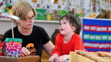Isaac Delporte, 4, from Sandgate, with producer Helen Morrison, gets some tips on playing the drums in the recycled instrument band segment for Sesame Street.