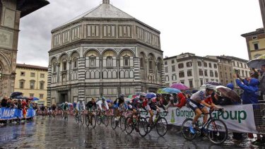 Riders cycle under heavy rain next to the San Giovanni Baptistery during the men's elite road race in Florence, Italy.