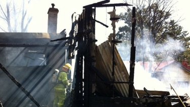 A firefighter inspects the ruins in Upwey.