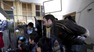 Voutas (right) directs a scene from <i>Red Light Revolution</i> on location in Beijing.