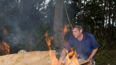 Labour of love ... James Dodd  shapes and fires a stringybark tree to make a traditional bark canoe.