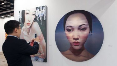 A visitor takes a photo of an artwork entitled 'Wind Angel' by Ling Jian on May 14, 2014 at the Hong Kong Convention and Exhibition Centre in Wan Chai, Hong Kong. 