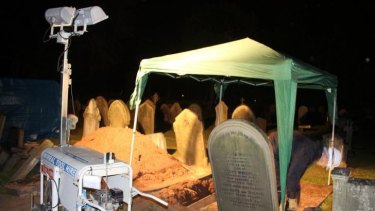In the dark: The exhumation of the grave of Thomas Bailey, Fred Deeming's brother, in May.