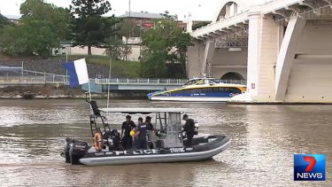 Police divers prepare to search the Brisbane River.