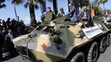 The Expendables 3 co-stars Arnold Schwarzenegger, Jason Statham and Harrison Ford arrive in Cannes by tank.