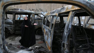 Scene of destruction: A woman gestures amid the carnage at the site of a car bomb in the Shula neighbourhood of Baghdad. It was one of several attacks on civilians in Iraq over the weekend.