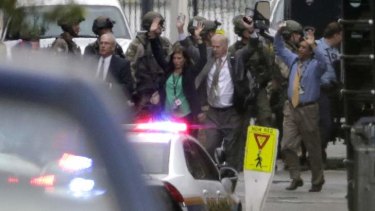 Evacuees raise their hands as they are escorted from the scene of a shooting at the Washington Navy Yard.