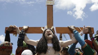 'John Michael', a 33-year-old Australian from Melbourne, grimaces in pain as he is nailed to the cross during Good Friday rites in Kapitangan village, Bulacan province, north of Manila, Philippines.
