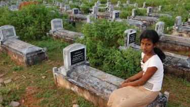 An unnamed woman by Tamil Tiger war graves.