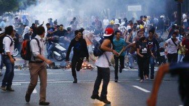 Anger boils over: Protesters run away from tear gas.