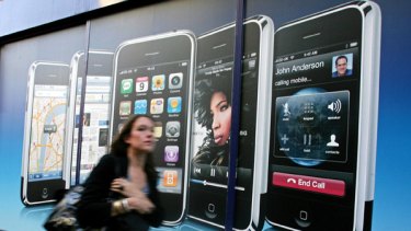A woman walks past an advertisement for Apple's iPhone product in central London.