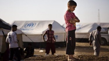 A boy, who fled from the violence in Mosul, stands near tents in a camp for internally displaced people on the outskirts of Arbil in Iraq's Kurdistan region. 