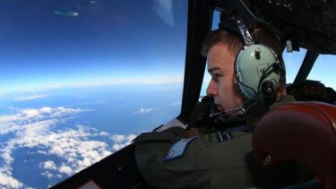 Tiring task ... Flight Lieutenant Russell Adams looks out from the cockpit of a Royal Australian Air Force (RAAF) AP-3C Orion aircraft while searching for the missing Malaysia Airlines Flight MH370 over the southern Indian Ocean.