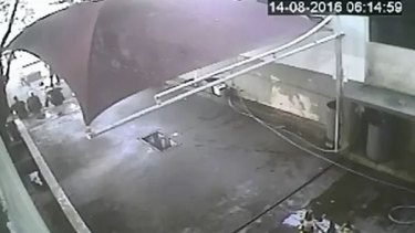 Part of the CCTV aired by Globo appears to show the swimmers, left, sitting on a curb at a car washing area of a petro station.