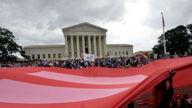 People wave a giant equality flag in celebration outside the Supreme Court in Washington on Friday. 