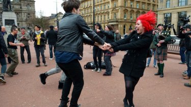 People dance in celebration in Glasgow.