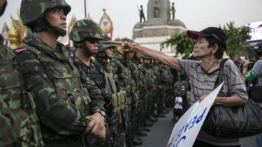 A Thai protester confronts soldiers during an anti-coup rally in Bangkok.