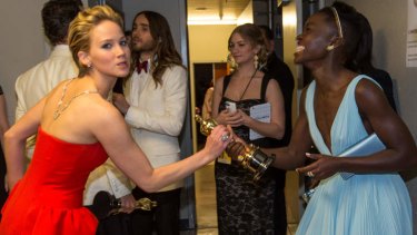 Best supporting actress nominee Jennifer Lawrence wrestles in jest with winner Lupita Nyong'o for her Oscar.