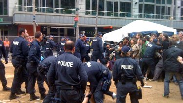 Police detain a man in City Square as other officers hold the crowd back.