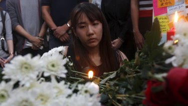 A woman lights a candle at the Erawan Shrine, the site of Monday's deadly blast.