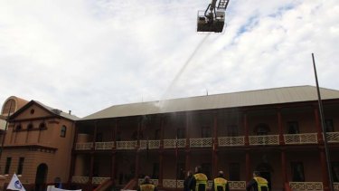 A real dampener ... NSW firefighters hose the roof of Parliament House in protest of the proposed workers compensation laws.