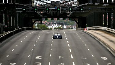 Mark Webber drives his car across the Sydney Harbour Bridge in a promotional event in 2005. 