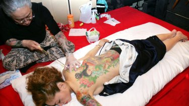 A woman gets tattoos in Japan.