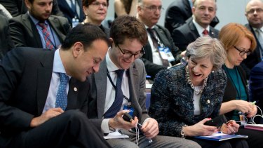 Irish Prime Minister Leo Varadkar, left, shows his decorative socks to British Prime Minister Theresa May,  during a round table meeting at an EU summit in Goteborg, Sweden on November 17.