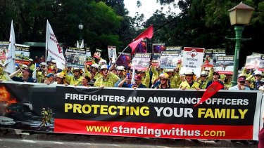 Hundreds of firefighters and ambulance officers stage a noisy demonstration at Parliament House.