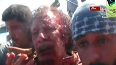 Bloody end ... in this still image provided by Reuters TV, a man believed to be Muammar Gaddafi, is pulled from a truck by NTC fighters in Sirte.