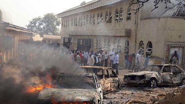 Bomb blast ... a car burns after an explosion at St Theresa Catholic Church at Madalla, Suleja, just outside Nigeria's capital Abuja.