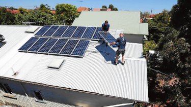 Peter Allan (top) removes solar panels from his Brunswick house in frustration at Government policies.