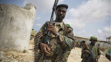 A Somali Transitional Federal Government soldier and African Union Mission in Somalia trooper stand guard in a camp.