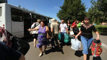 Fleeing residents of Shakhtersk run towards buses provided by pro-Russian rebels after heavy shelling.