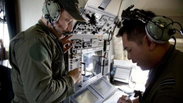 Crew members aboard a Royal Australian Air Force AP-3C Orion aircraft observe navigation maps as they search for missing Malaysian Airlines flight MH370 over the southern Indian Ocean.
