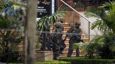 Soldiers from the Kenya Defense Forces carry a wounded colleague out of the Westgate Mall.