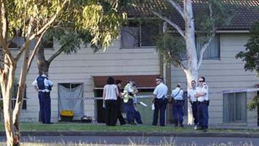 Police interview bystanders at the Fowlers Road, Koonawarra property yesterday.