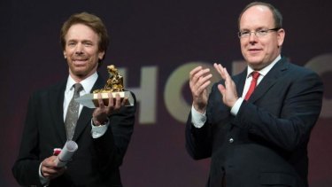 Prince Albert II of Monaco (R) applauds after delivering the lifetime achievement award to US film and TV producer Jerry Bruckheimer (L), during the 54th Monte-Carlo Television Festival in Monaco.