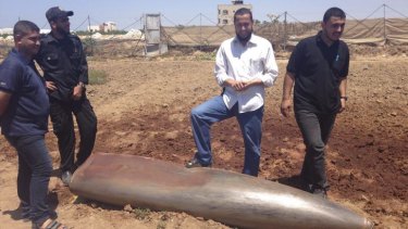 Hazem Abu Murad (in white shirt) stands with members of his munitions disposal team on Thursday.