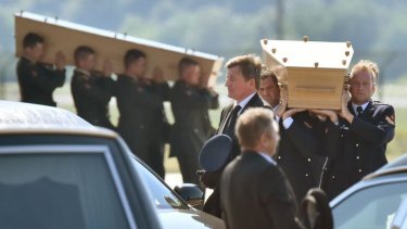 Dutch military men carry coffins containing the bodies of MH17 victims during a ceremony at Eindhoven Airbase after a Hercules transport plane landed from Ukraine.